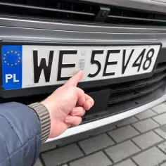 Ręka wskazuje na hologram na tablicy rejestracyjnej. Zastanawiasz się, ile się czeka na dowód rejestracyjny?
