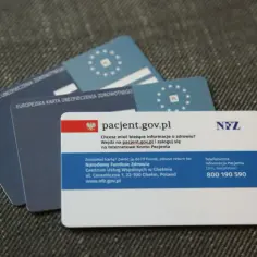 Kilka kart ubezpieczenia zdrowotnego, w tym karta EKUZ i karta pacjenta z adresem pacjent.gov.pl.