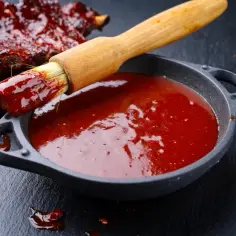 Pyszne żeberka w sosie barbecue, pędzelek zanurzony w sosie, idealny przepis na sos barbecue.