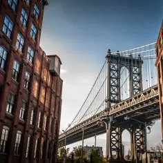 Ceglane budynki i majestatyczny most Manhattan Bridge tworzą malowniczy widok. Czy Brooklyn jest bezpieczny? Ten widok sugeruje spokój i piękno.