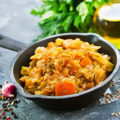 Jak ugotować dobry bigos z młodej kapusty? Aromatyczne danie w żeliwnej patelni, z dodatkiem czosnku, ziół i przypraw.