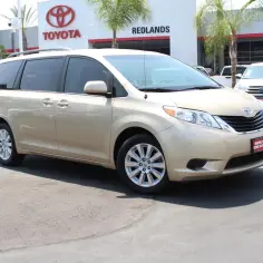 Złoty minivan Toyota Sienna 2025 zaparkowany przed salonem Toyoty w Redlands.