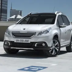 Biały Peugeot 2008, idealny SUV do 40 tys. zł, zaparkowany na dachu budynku.