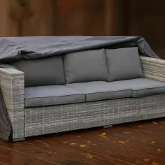 Sofa z technorattanu przykryta pokrowcem, gotowa na zimę. Czy technorattan może stać na mrozie? Tak, ale warto go zabezpieczyć.