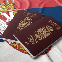 Dwa paszporty Republiki Serbii leżą na fladze Serbii. Czy do Serbii potrzebny jest paszport? Tak, do podróży do Serbii wymagany jest paszport.