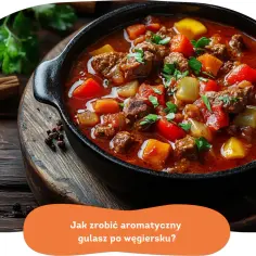 Aromatyczny gulasz po węgiersku w czarnym naczyniu, z kawałkami mięsa, papryki i ziemniaków, ozdobiony natką pietruszki.