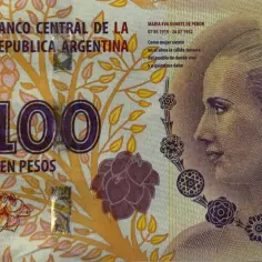 Argentyński banknot 100 peso z portretem Evity Perón i motywami roślinnymi.