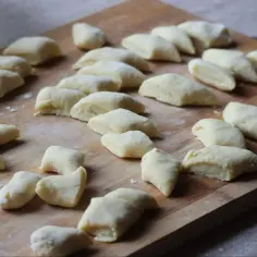 Kopytka gotowe do gotowania, uformowane z ciasta, które idealnie pokazuje, ile mąki do kopytek potrzeba.