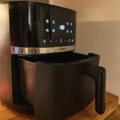 Czarny air fryer Bosch z wysuniętą szufladą. Dowiedz się, jak usunąć zapach spalenizny z air fryera po pierwszym użyciu.
