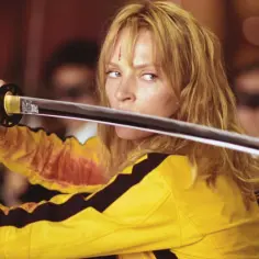 Uma Thurman w żółtym stroju z filmu "Kill Bill" trzyma katanę.