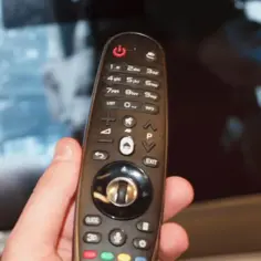 Dłoń trzyma pilota od telewizora. Zastanawiasz się, czy można odbierać telewizję naziemną bez anteny? Ten pilot może pomóc Ci znaleźć odpowiedź.