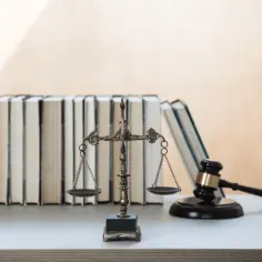 Waga sprawiedliwości, młotek sędziowski i stos książek, symbolizujące prawo i wiedzę. 160 kk.