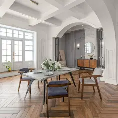 Elegancki salon z jadalnią, gdzie łuk stanowi centralny punkt. Aranżacja wnętrza pokazuje, jak wykończyć łuk w salonie, tworząc stylowe przejście.