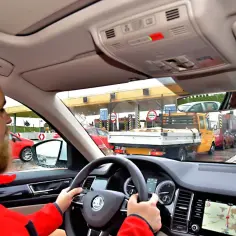 Kierowca zbliża się do bramek opłat, pokazując, jak działa system poboru opłat, podobny do tego w Blablacar.
