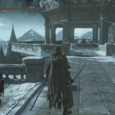 Postać w zbroi przemierza ośnieżone ruiny Anor Londo, z widokiem na mroźne góry i strzeliste wieże.