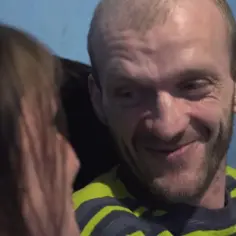 Uśmiechnięty Ryszard Szczena w bluzie w paski, patrzący na kogoś z boku.