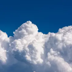 Białe, puszyste chmury na tle błękitnego nieba.