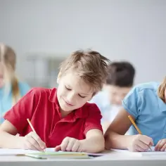 Dzieci w szkole pilnie odrabiają lekcje, wypełniając obowiązek szkolny w Polsce.