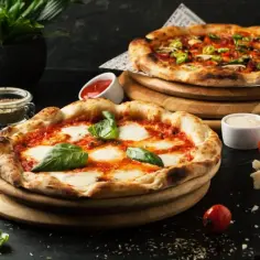 Dwie pyszne pizze, idealne na dzień pizzy. Jedna margherita z bazylią, druga z warzywami i serem.