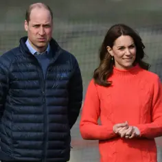 Księżna Kate w czwartej ciąży, uśmiechnięta, w jaskrawym swetrze, obok księcia Williama w granatowej kurtce.