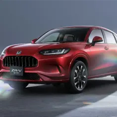 Błyszczący czerwony Honda ZR-V e:HEV z eleganckim grillem i reflektorami LED, gotowy na przygodę.