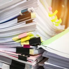 Stosy dokumentów, gdzie szukać świadectwa pracy? Kolorowe spinacze i zakładki pomagają w organizacji.