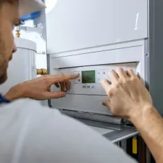Instalator ustawia piec gazowy. Poznaj koszt instalacji gazowej w domu i ciesz się ciepłem.