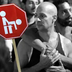 Znak stop z symbolem nawiązującym do homoseksualizmu, trzymany przez obejmujących się mężczyzn.