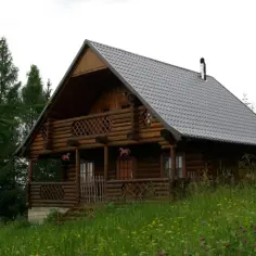 Drewniany domek letniskowy w otoczeniu drzew. Właściciel zastanawia się nad podatkiem od domku letniskowego.