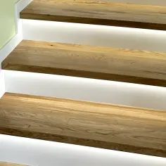 Nowe schody z drewna dębowego z podświetleniem LED. Zobacz, jak zamontować listwy przy schodach, by uzyskać nowoczesny efekt.