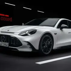 Biały Mercedes-AMG GT 4-Door Coupé prezentuje swoją sportową sylwetkę na ciemnym tle z białymi pasami drogowymi.