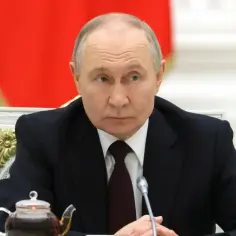 Władimir Putin siedzi przy stole, obok czajniczka z herbatą. W tle widać fragment rosyjskiej flagi.