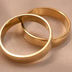 Dwie złote obrączki, symbol miłości. Zastanawiasz się, ile gram złota na dwie obrączki?