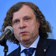 Prezydent Sopotu, mężczyzna z kręconymi włosami, przemawia do mikrofonu.