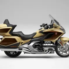Złoty motocykl Honda Goldwing z brązowymi akcentami, gotowy na dalekie podróże.