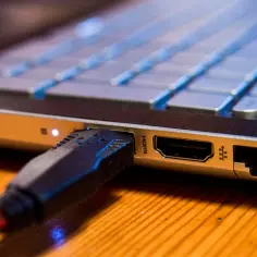Podłączanie monitora do laptopa przez HDMI. Wtyczka kabla HDMI w porcie laptopa.