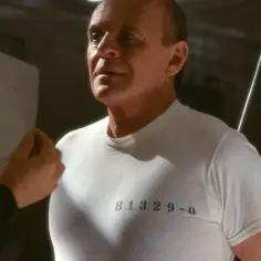 Anthony Hopkins w białej koszulce z numerem B1329-0, przypominający scenę z jego kultowych filmów.