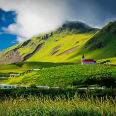 Zielona Islandia z kościołem na wzgórzu. Zastanawiasz się, ile trwa lot do Islandii?