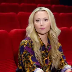 Anna Eriksson siedzi w pustej sali kinowej, ubrana w kolorową koszulę.