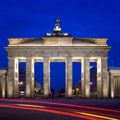 Brama Brandenburska nocą, z rozmazanymi światłami samochodów. Ciekawe ciekawostki o Berlinie czekają!