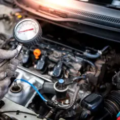 Mechanik sprawdza jakie minimalne ciśnienie sprężania diesel za pomocą manometru.