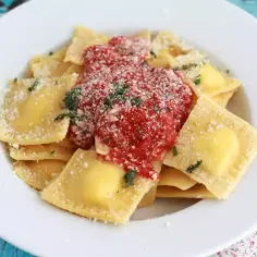 Pyszne ravioli z ricottą, polane sosem pomidorowym i posypane parmezanem. Idealne na szybki obiad.