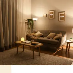 Przytulny salon z sofą, stolikiem i dywanem. Ciepłe kolory i miękkie światło tworzą relaksującą atmosferę.