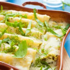 Zapiekane cannelloni w sosie śmietanowym, posypane ziołami.