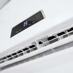 Biały klimatyzator ścienny z wyświetlaczem pokazującym 23°C.