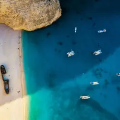 W Grecji jest morze, nie ocean. Widok na plażę Navagio z wrakiem statku i łodziami na turkusowej wodzie.