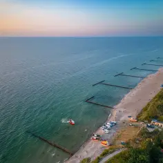 Piękna plaża w Jarosławcu z łodziami i falochronami. Idealne miejsce na rodzinne wakacje, gdzie znajdziesz mnóstwo atrakcji dla dzieci.