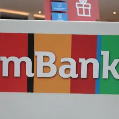 Logo mBank z białymi literami na kolorowym tle: czerwonym, pomarańczowym, czerwonym, niebieskim i zielonym.