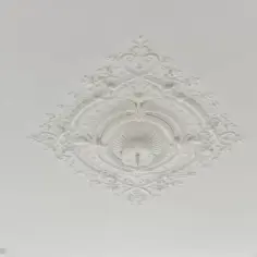 Elegancka, biała rozeta na suficie, ozdobiona misternymi wzorami roślinnymi i geometrycznymi.