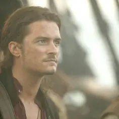 Orlando Bloom w filmach pirackich, zamyślony, z brodą i w kapeluszu, obok innych postaci.